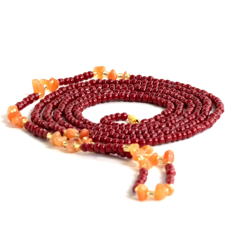 Red beads, transparent gold accents, and alluring brownish-orange crystals waist beads with clasp. Solo African waist beads against a white background. .