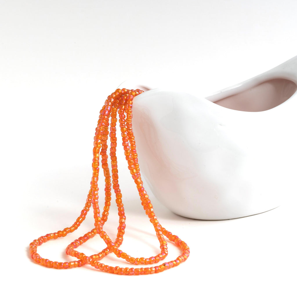 Transparent orange waist beads with clasp with pink and yellow hues. 